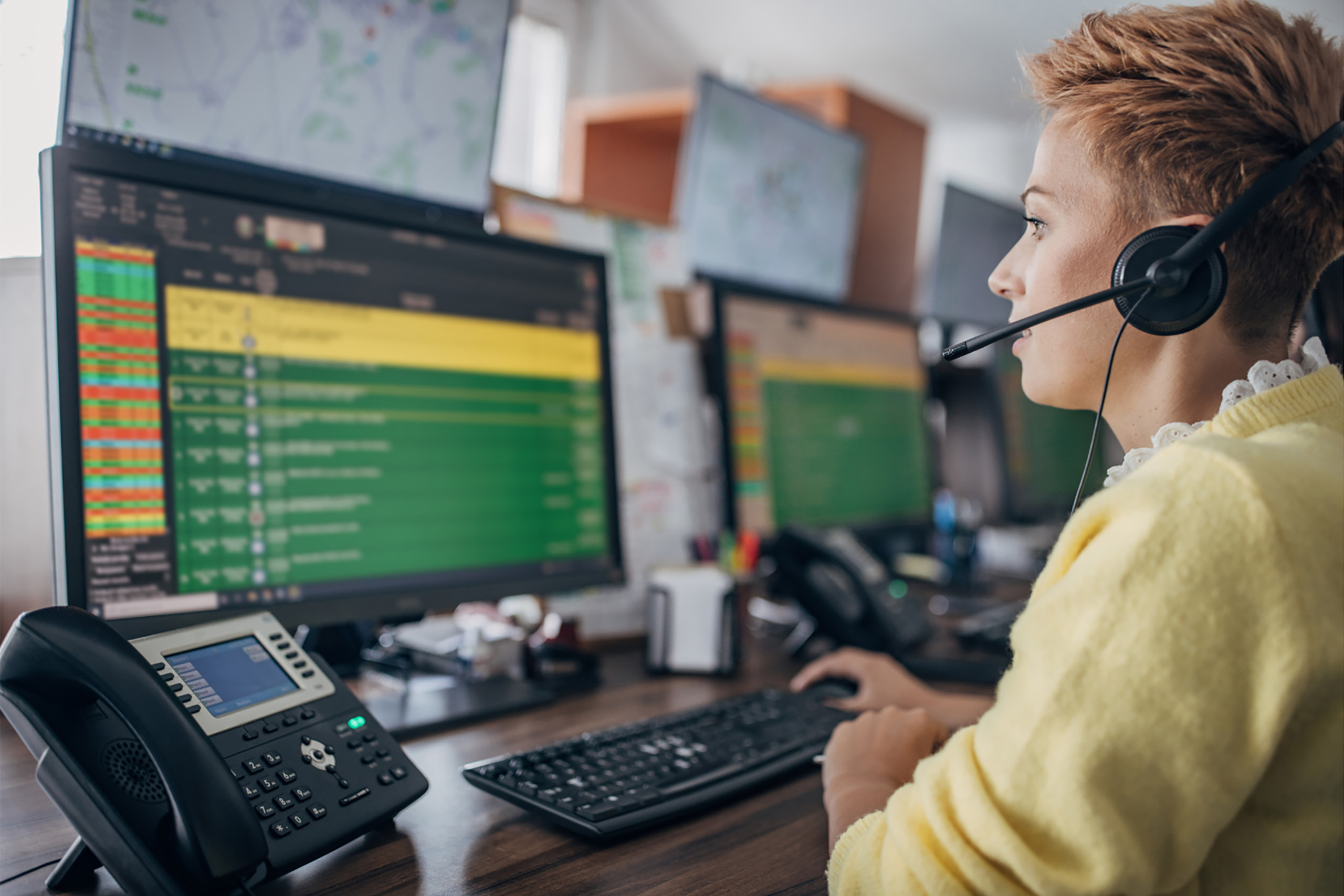 Dispatch officer with short red hair, dispatching calls on a computer screen
