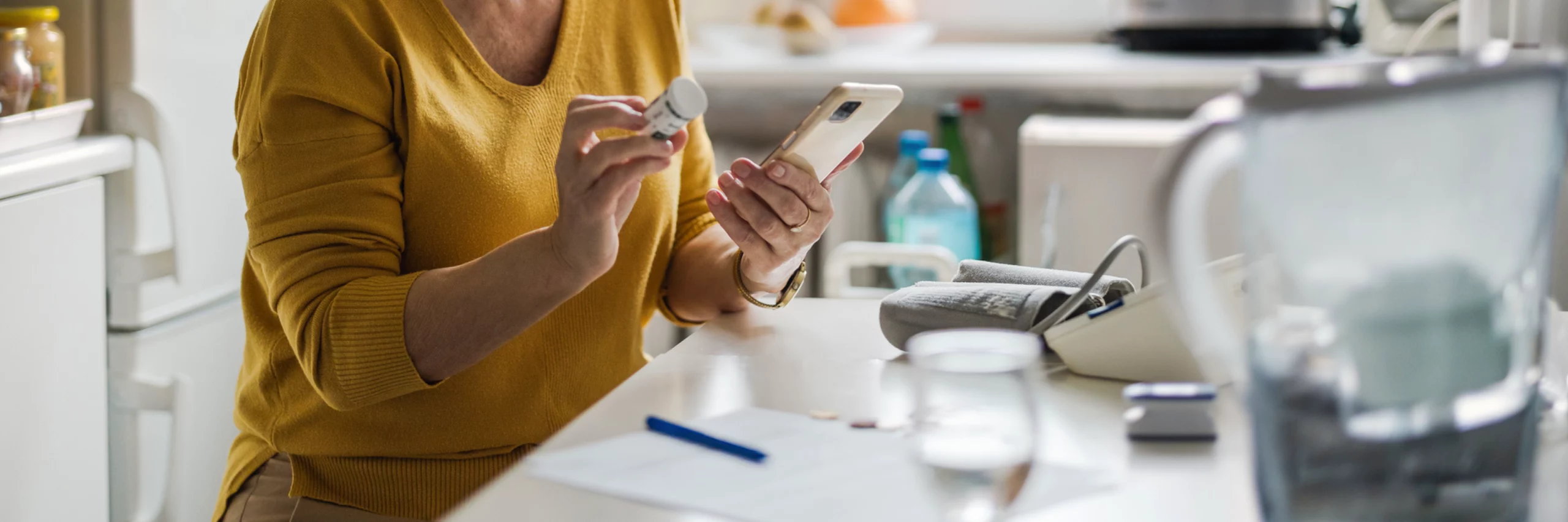 Undistinguishable woman examining prescription bottle while talking on her cellphone