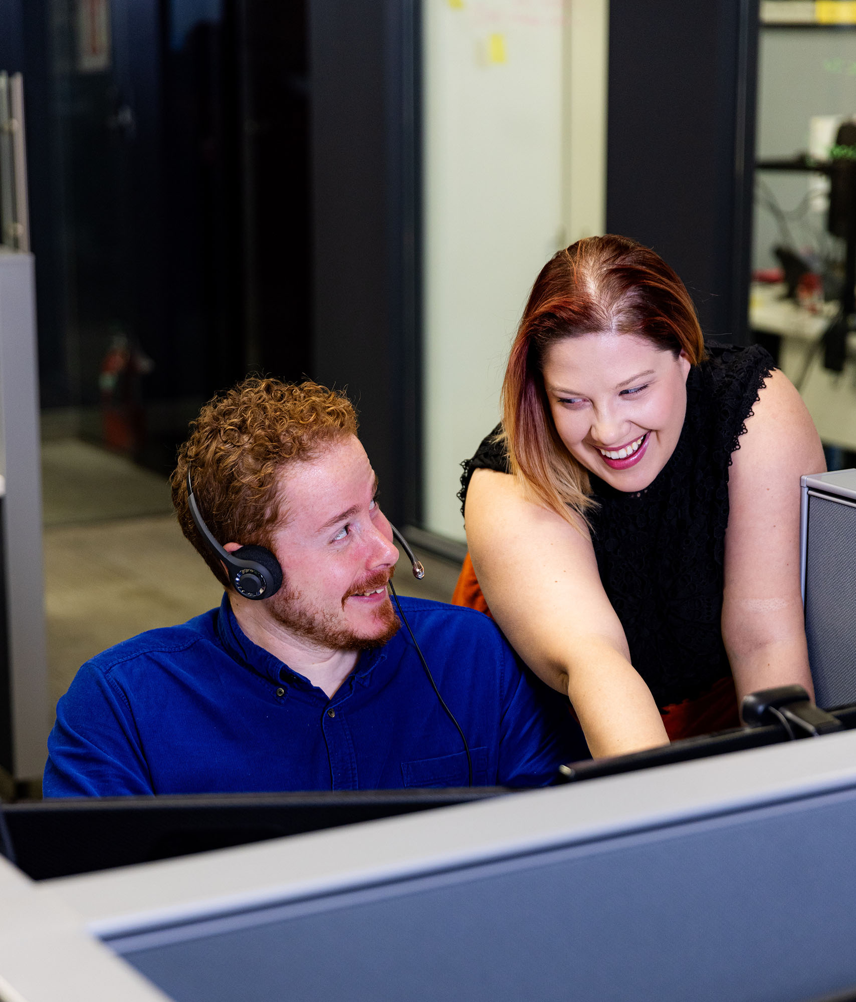 Julian and another AnswerPlus employee huddling around a desk