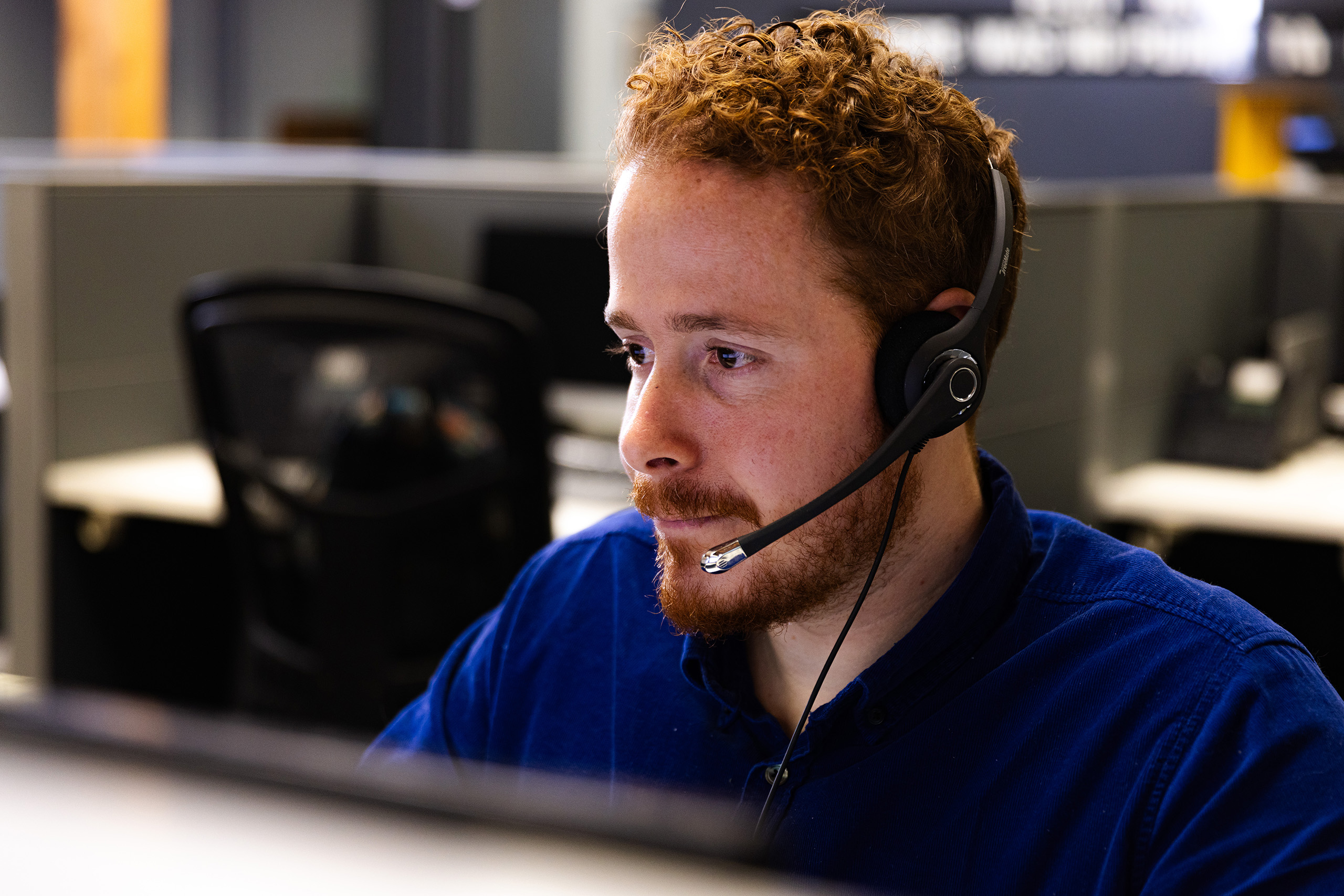 Julian, a CSR at AnswerPlus, wearing a blue shirt